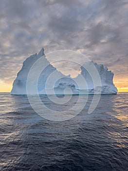 A huge high breakaway glacier drifts in the southern ocean off the coast of Antarctica at sunset, the Antarctic