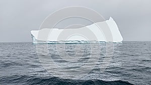 A huge high breakaway glacier drifts in the southern ocean off the coast of Antarctica at sunset, the Antarctic