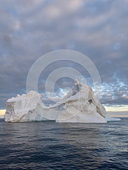 A huge high breakaway glacier drifts in the southern ocean off the coast of Antarctica at sunset, the Antarctic