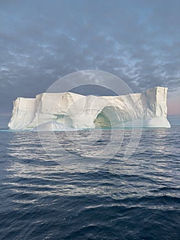 A huge high breakaway glacier drifts in the southern ocean off the coast of Antarctica at sunset, the Antarctic