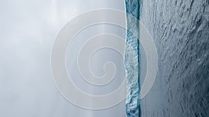 A huge high breakaway glacier drifts in the southern ocean off the coast of Antarctica at sunset, the Antarctic