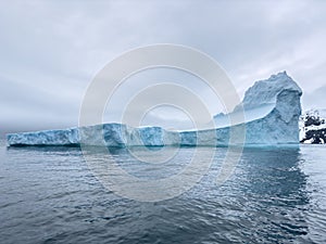 A huge high breakaway glacier drifts in the southern ocean off the coast of Antarctica at sunset, the Antarctic