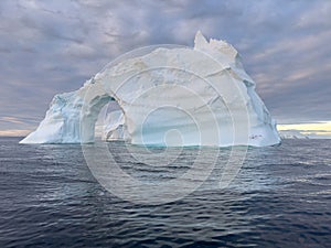 A huge high breakaway glacier drifts in the southern ocean off the coast of Antarctica at sunset, the Antarctic