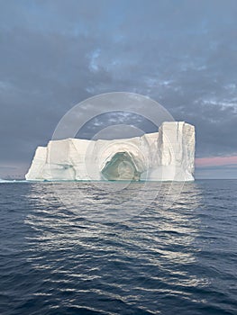 A huge high breakaway glacier drifts in the southern ocean off the coast of Antarctica at sunset, the Antarctic