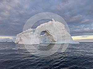 A huge high breakaway glacier drifts in the southern ocean off the coast of Antarctica at sunset, the Antarctic