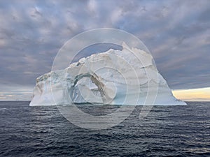 A huge high breakaway glacier drifts in the southern ocean off the coast of Antarctica at sunset, the Antarctic