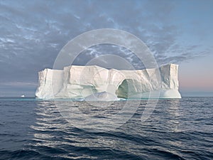 A huge high breakaway glacier drifts in the southern ocean off the coast of Antarctica at sunset, the Antarctic