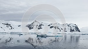 A huge high breakaway glacier is passing by in the southern ocean off the coast of Antarctica, the Antarctic Peninsula