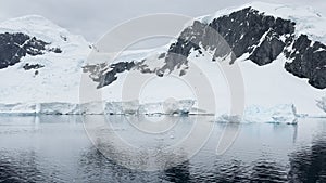 A huge high breakaway glacier is passing by in the southern ocean off the coast of Antarctica, the Antarctic Peninsula