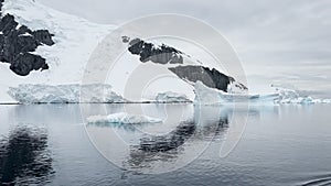 A huge high breakaway glacier is passing by in the southern ocean off the coast of Antarctica, the Antarctic Peninsula