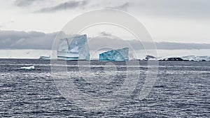 A huge high breakaway glacier is passing by in the southern ocean off the coast of Antarctica, the Antarctic Peninsula