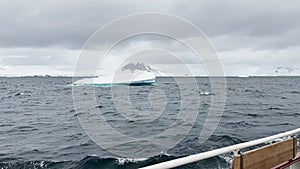 A huge high breakaway glacier is passing by in the southern ocean off the coast of Antarctica, the Antarctic Peninsula