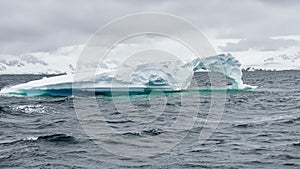 A huge high breakaway glacier is passing by in the southern ocean off the coast of Antarctica, the Antarctic Peninsula