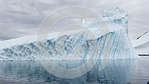 A huge high breakaway glacier is passing by in the southern ocean off the coast of Antarctica, the Antarctic Peninsula