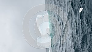 A huge high breakaway glacier is passing by in the southern ocean off the coast of Antarctica, the Antarctic Peninsula