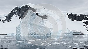 A huge high breakaway glacier is passing by in the southern ocean off the coast of Antarctica, the Antarctic Peninsula