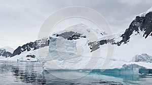 A huge high breakaway glacier is passing by in the southern ocean off the coast of Antarctica, the Antarctic Peninsula