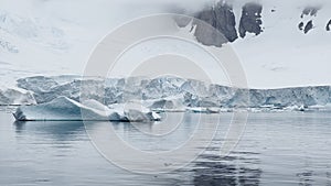 A huge high breakaway glacier is passing by in the southern ocean off the coast of Antarctica, the Antarctic Peninsula