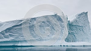 A huge high breakaway glacier is passing by in the southern ocean off the coast of Antarctica, the Antarctic Peninsula