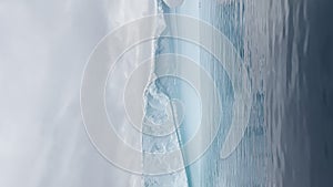 A huge high breakaway glacier is passing by in the southern ocean off the coast of Antarctica, the Antarctic Peninsula