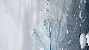 A huge high breakaway glacier is passing by in the southern ocean off the coast of Antarctica, the Antarctic Peninsula
