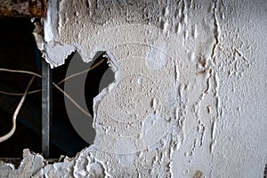 A huge hole of ceiling panels was damages from rainwater leakage in the abandoned house. Ceiling floor swelling and have fungi.