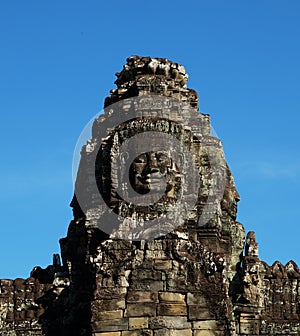 A huge human face built of stone blocks. Huge human faces on the towers of the Bayon temple in Cambodia. Architectural art of