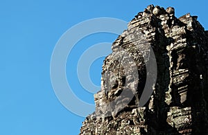 A huge human face built of stone blocks. Huge human faces on the towers of the Bayon temple in Cambodia. Architectural art of