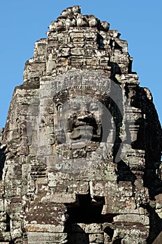 A huge human face built of stone blocks. Huge human faces on the towers of the Bayon temple in Cambodia. Architectural art of