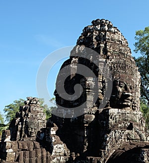 A huge human face built of stone blocks. Huge human faces on the towers of the Bayon temple in Cambodia. Architectural art of