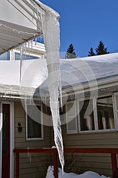 Dangerously huge icicle hanging from an eavestrough photo