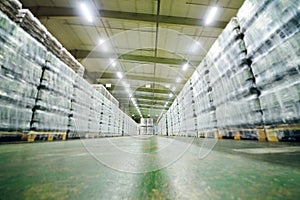 huge industrial warehouse with plastic food wrap wrapped plastic bottles with carbonated drinks, water or beer.