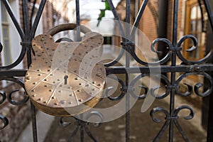 A huge iron barn lock on a metal lattice-gate of the entrance to the courtyard