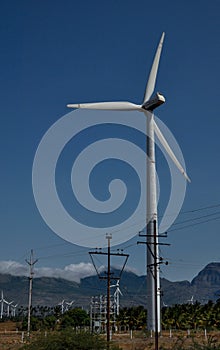 A single isolated huge wind mill in a field in india