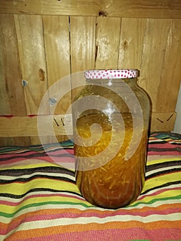 huge jar with honey liquid and ginger