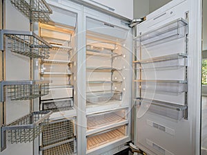 Huge modern refrigerator with empty shelves in a kitchen.