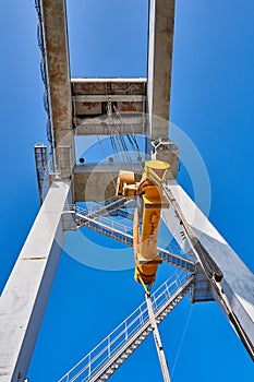 A huge multi-ton port crane lifts and unloads cargo