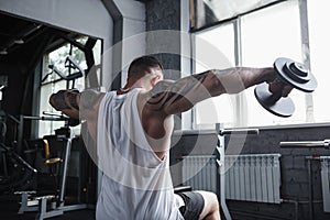 Huge muscular man training at bodybuilding gym