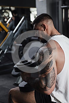Huge muscular man training at bodybuilding gym