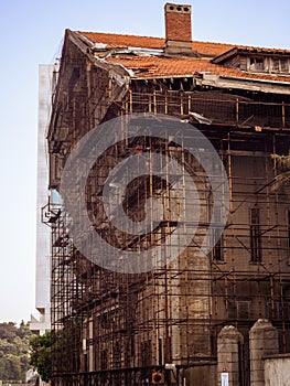 A huge old building under reconstruction, restoration or rebuilding, surrounded by scaffolding.