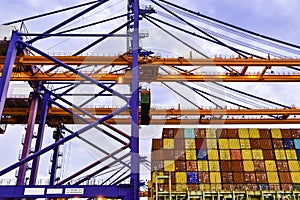 Huge panamax size container vessel discharging and loading container cargo at port terminal.