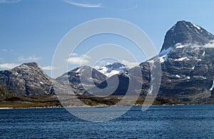 A huge peak rises up above the Greenland icecap on the edge of the Arctic Ocean