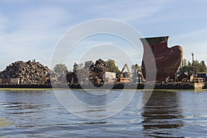 A huge pile of metal scrap and a gigantic metal kiel in the port of Gdansk. Poland