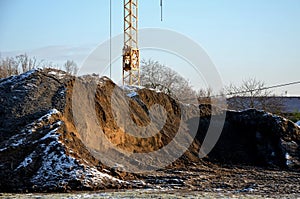 Huge piles of clay and soil are materials moved during the excavation of the foundations of an apartment building. a large constru