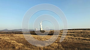 Huge pipes of a thermal power plant smoke slightly in the production process. Industrial landscape, atmospheric