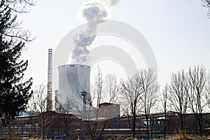 Huge pipes of a thermal power plant smoke slightly in the production process. Industrial landscape, atmospheric