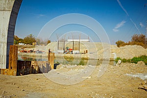 Huge pole in foundation with metal piles, construction of concrete-reinforced bridge pillars at building site