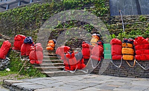 Huge red backpacks for mountain expedition on stairs. Porter Mountaineering equipment.