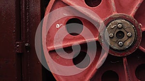 Huge red round handle of mechanism of hydraulic sluice gate on the dam