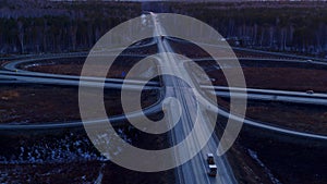 Huge road junction full of cars and trucks in countryside in winter, aerial view.